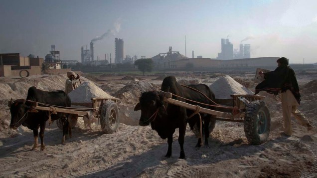 Paquistaneses recolhem areia para confecção de tijolos em Multan