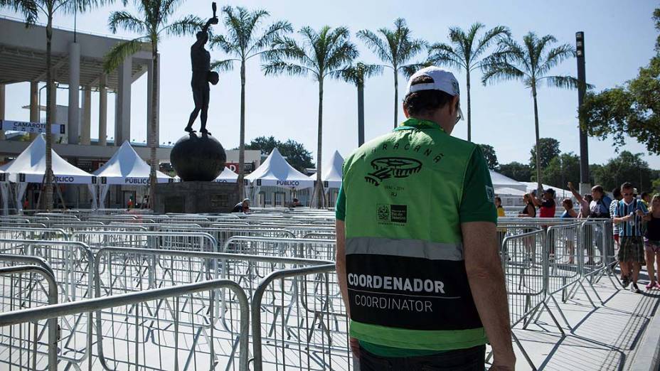 André Lazaroni caminha pelas grades ainda vazias da entrada do Maracanã, em frente à estatua do ex-jogador brasileiro Hilderaldo Luiz Bellini