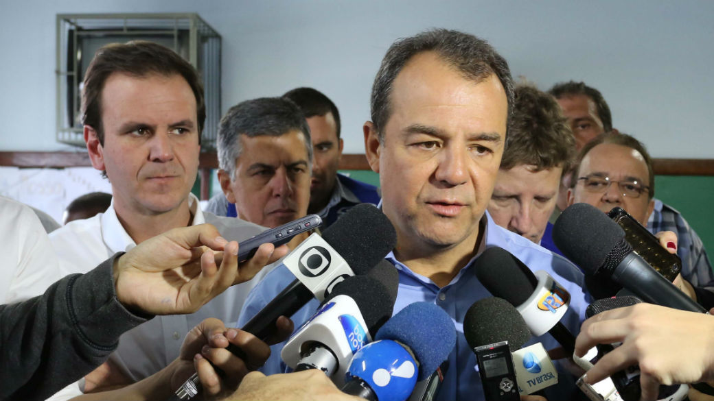 Sérgio Cabral é observado por aliados em entrevista no bairro de Campo Grande
