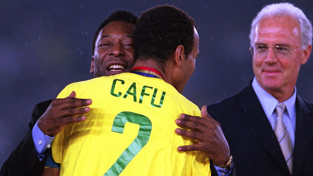 Pelé abraça Cafu antes de entregar a taça na conquista do penta, em 2002; ao lado deles, Beckenbauer, também eleito para o time dos sonhos da revista 'World Football'