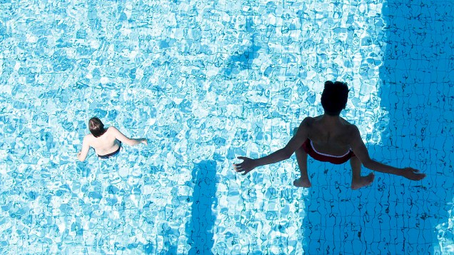 Meninos pulam em piscina, na Alemanha, nesta sexta-feira. Meteorologistas apontam tempo quente com temperaturas rondando 25º C na próxima semana no país