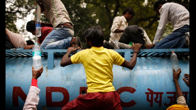 Agricultores enchem garrafas dàgua durante protesto em Nova Délhi, na Índia