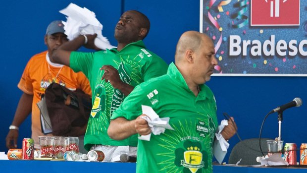O diretor de carnaval da Camisa Verde e Branco, Alexandre Salomão (à frente), rasga e amassa envelopes com notas das escolas
