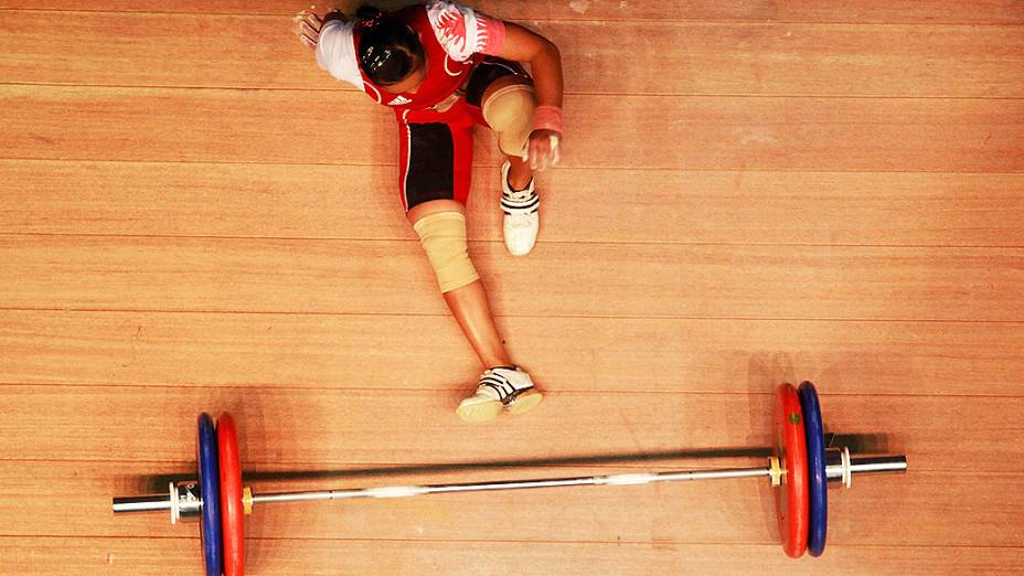Febrianti Citra da Indonésia cai durante o segundo dia do campeonato Asiático de levantamento de peso em Pyeongtaek, na Coréia