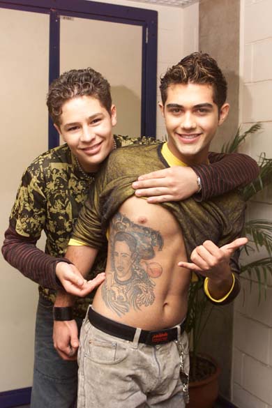 Pedro mostrando tatuagem com o rosto do cantor Leandro, no corpo de Thiago, em 2002 Pedro mostrando tatuagem com o rosto do cantor Leandro, no corpo de Thiago, em 2002