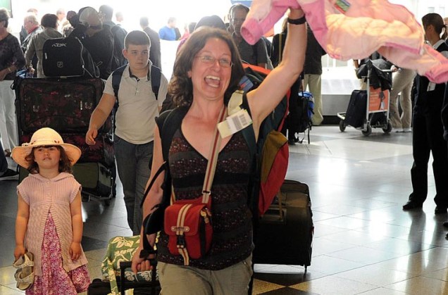 Turista alemã que passou férias na Espanha comemora chegada ao aeroporto de Munique, na Alemanha.