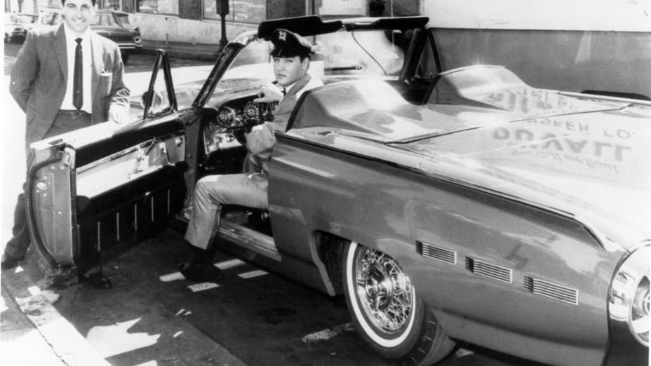 Feliz da vida com seu novíssimo Ford Thunderbird 1962 Sport Roadster, Elvis posa ao lado do vendedor de carros Ernie Barrasso. Mas a alegria durou pouco. O Rei devolveu o carro dias depois, após o conversível apresentar problemas nas rodas. Ele mesmo ligou para Edsel Ford, presidente da montadora na época, para reclamar do defeito