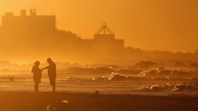 Pessoas na praia de Coney Island, Nova York, um dia após a passagem do furacão Irene