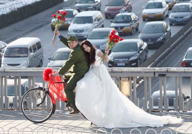 Casal de noivos posa para fotografia, após o “casamento nu”, expressão popular na China para casais jovens que se casam sem casas, carros ou poupança em bancos