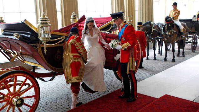William ajuda Kate a descer da carruagem no palácio Buckingham, local onde o casal recebeu alguns convidados após a cerimônia de casamento