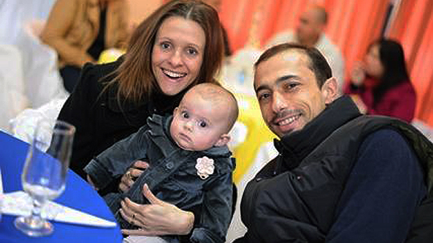 O pai do menino Bernardo Boldrini, Leandro, e a madrasta Graciele Ugulini Boldrini, seguram a bebê de 1 ano e seis meses