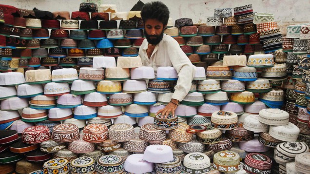 Vendedor exibe os tradicionais chapéus Taqiyah em uma barraca em Karachi, Paquistão