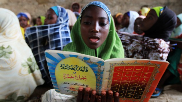 Menina lê versos do Corão, no segundo dia do mês sagrado do Ramadã, em Kano, Nigéria