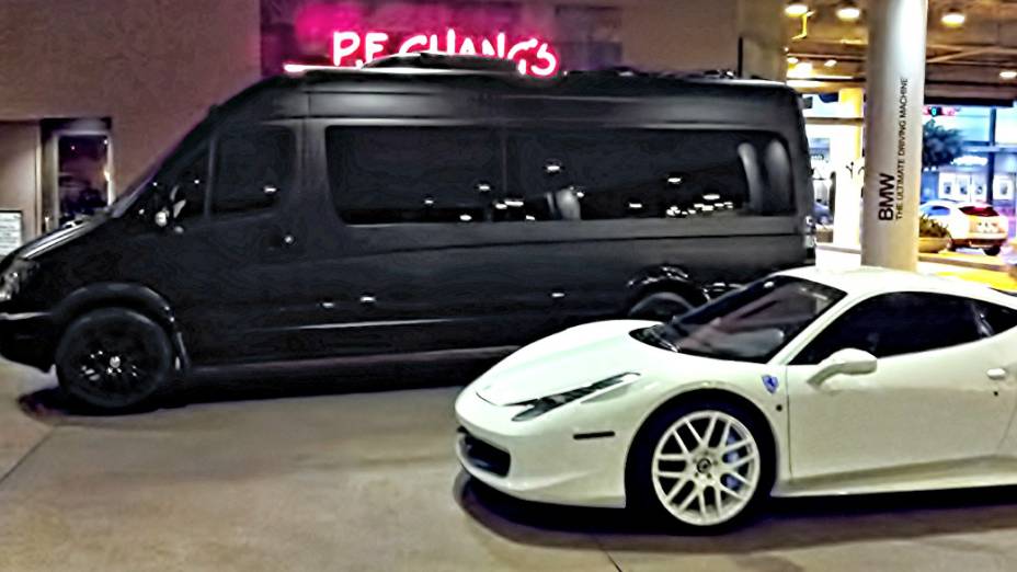 A van Sprinter preto fosco posa ao lado da Ferrari 458 Italia branca