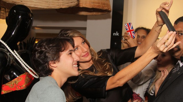 Gisele Bündchen faz selfie com fã durante o evento realizado na loja de Natalie Klein, em São Paulo