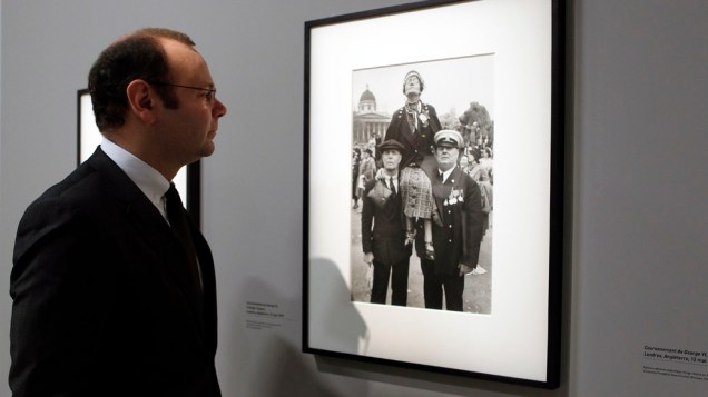 Um dos organizadores da exposição observa uma das fotografias de Henri Cartier-Bresson