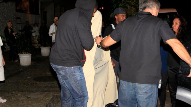 Justin Bieber, coberto por um lençol branco sai de uma boate em Ipanema, no Rio de Janeiro