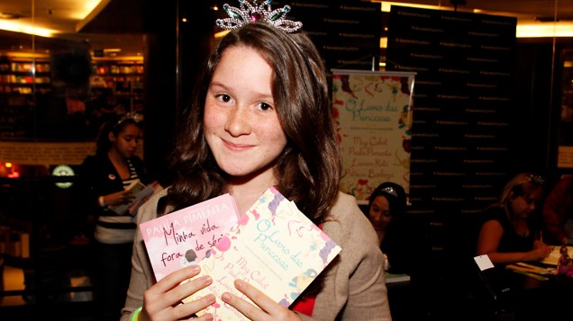 Ana Vitoria Moraes Oliveira, de 11 anos, mostra os livros que pediria para as escritoras autografarem