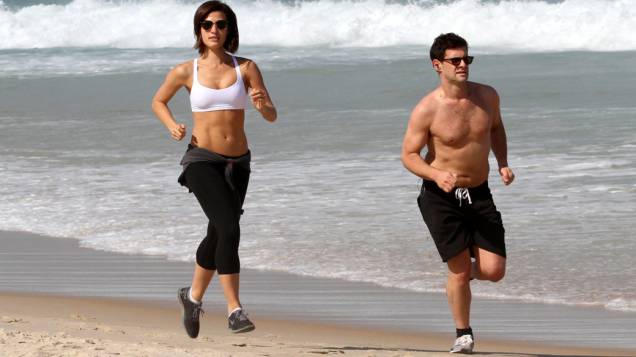 Justin Bartha faz cooper com a namorada na praia da zona sul do Rio