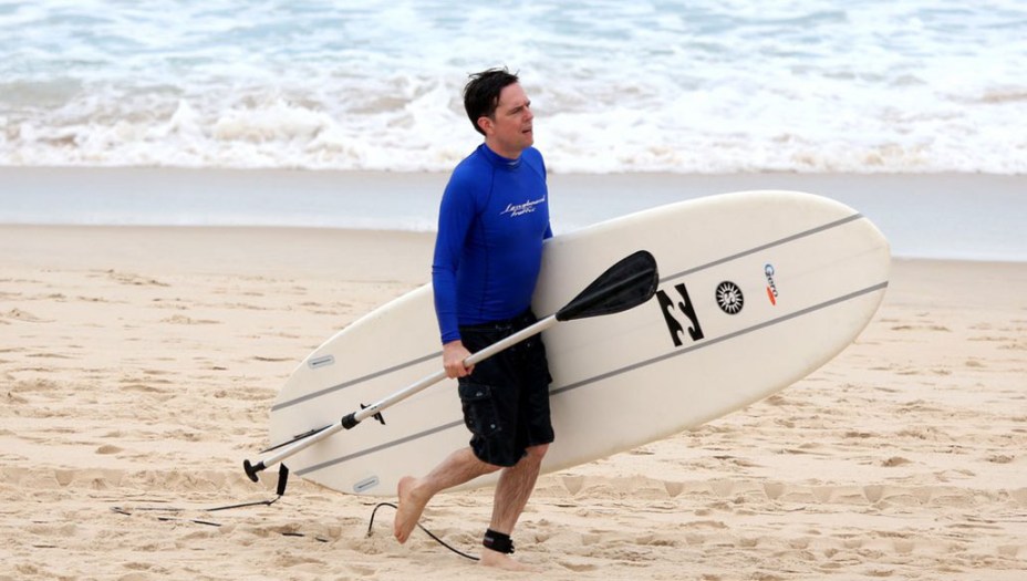Ed Helms ator do filme Se Beber não case 3 faz Stand Up Paddle em praia no Rio de Janeiro