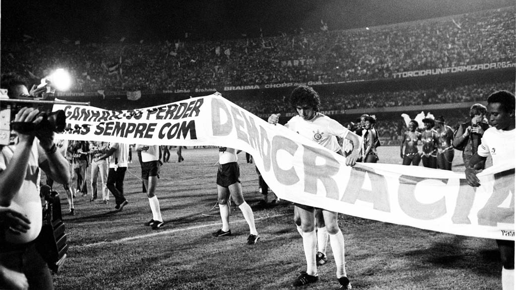 Em 1981, o publicitário e corintiano Washington Olivetto criou a campanha “Democracia Corintiana”, que apoiou a campanha das Diretas Já. Acima, jogadores do Corinthians divulgam a campanha em partida contra o São Paulo, válida pela final do Campeonato Paulista de 1983, conquistado pela equipe alvinegra