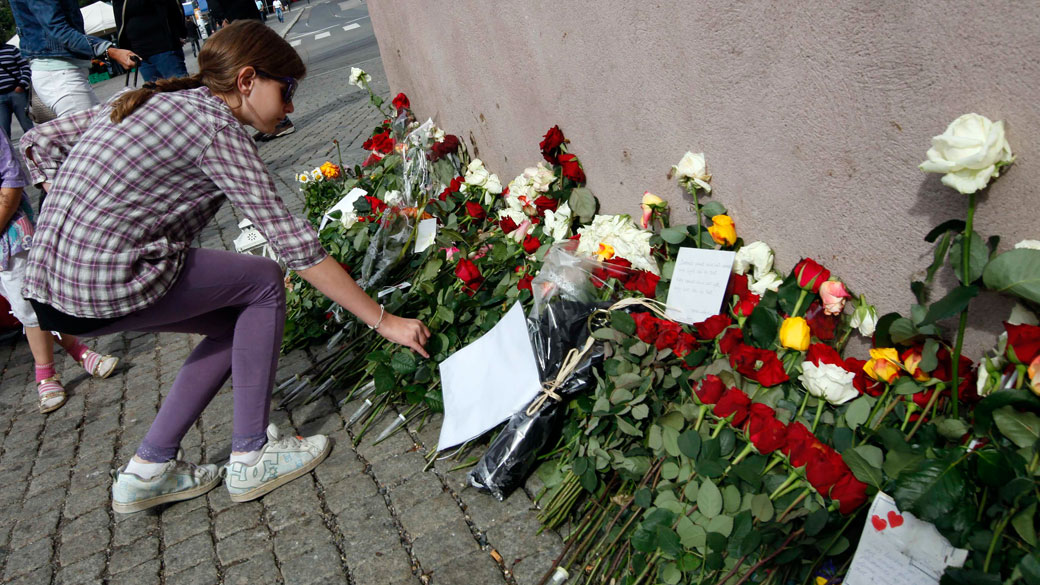 Garota coloca flores em frente a Catedral de Oslo, durante as cerimônias pelas vítimas do atentado que matou 77 pessoas na Noruega - 21/08/2011