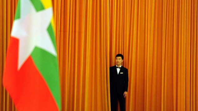 Em Pequim, membro da equipe de segurança chinesa aguarda o início da cerimônia de boas vindas ao presidente Thein Sein, de Mianmar