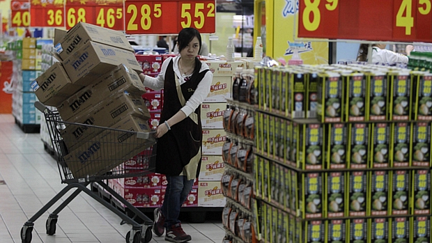 Funcionária repõe produtos em supermercado da cidade chinesa de Wuhan: apesar do aumento no consumo, PIB do país recuou no 3º trimestre