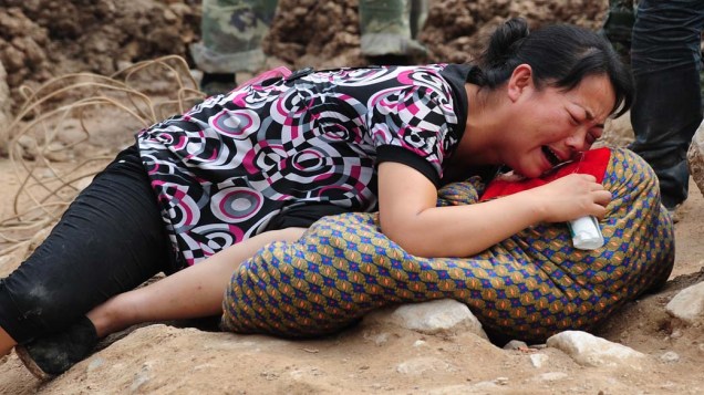 Mulher chora sobre corpo de seu filho, morto em Zhouqu, na China. O país sofre com deslizamentos decorrentes das chuvas, que já mataram 700 pessoas e deixaram cerca de 1000 desaparecidos