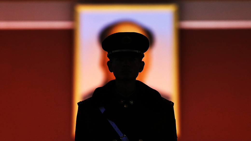 Silhueta de policial em frente ao retrato de Mao Tsé-tung durante o Congresso Nacional do Partido Comunista da China, em 12/11/2012