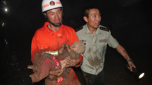 Bebê é resgatada de buraco de rua em Harbin, na China nesta terça-feira. Duas pessoas morreram ao cair no buraco que se abriu durante uma obra