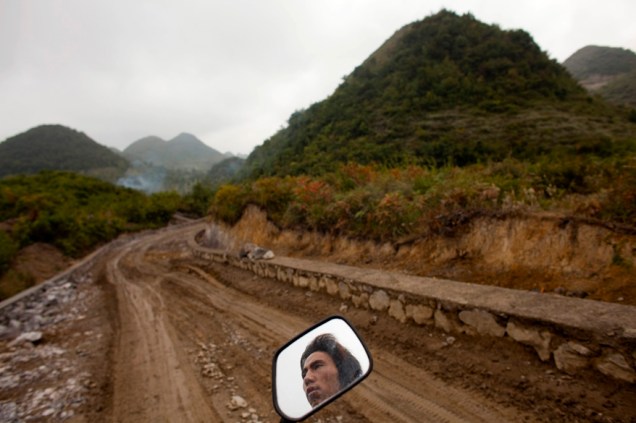 De moto, homem deixa sua vila em Heshan, na província de Guizhou, para ir trabalhar na cidade