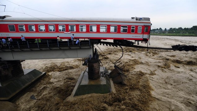 Trem em ponte destruída pelas águas, em Guanghan, no sudoeste da China. A área está sendo atingida por enchentes