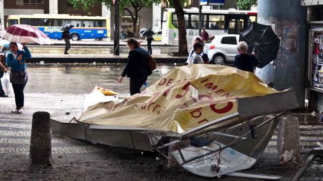 Cariocas se protegem da chuva e do forte vento na região da Avenida Presidente Vargas, esquina com Rio Branco, nesta segunda-feira (6)