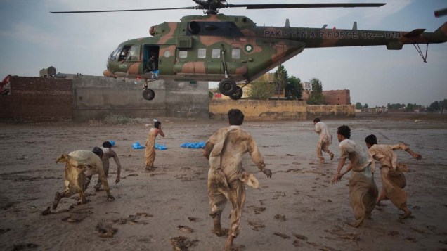 No Paquistão, moradores correm para pegar garrafas d’água distribuidas pela Força Aérea