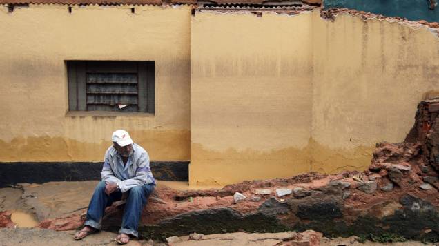 Morador senta nos destroços de sua casa após as fortes chuvas que atingiram Teresópolis, Rio de Janeiro - 13/01/2011