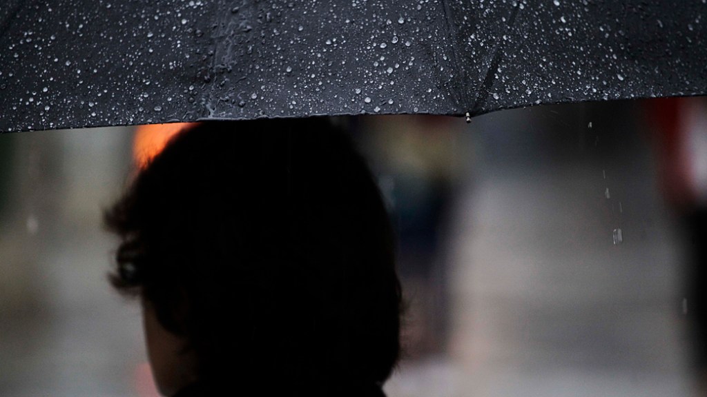 Pessoas se protegem da chuva em São Paulo: cena não se repete há 41 dias