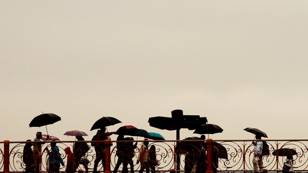 Pessoas se protegem da chuva e do frio que atinge a cidade de Sao Paulo, no viaduto Santa Ifigênia, centro da capital