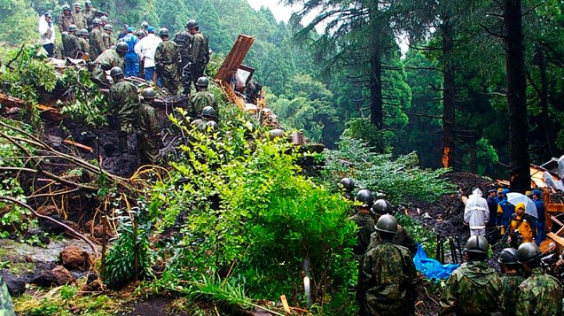 Soldados se reúnem durante busca por desaparecidos em Aso, na província de Kumamoto, no Japão. Fortes chuvas atingiram o sul do país, causando inundações, deslizamentos e destruindo dezenas de residências