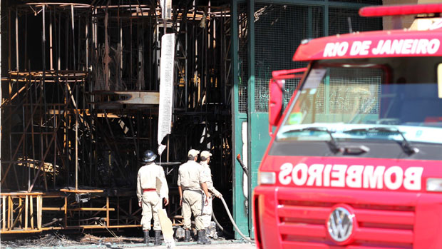 Bombeiros trabalham no rescaldo dos barracões incendiados na Cidade do Samba: relatório de 2010 apontava problemas