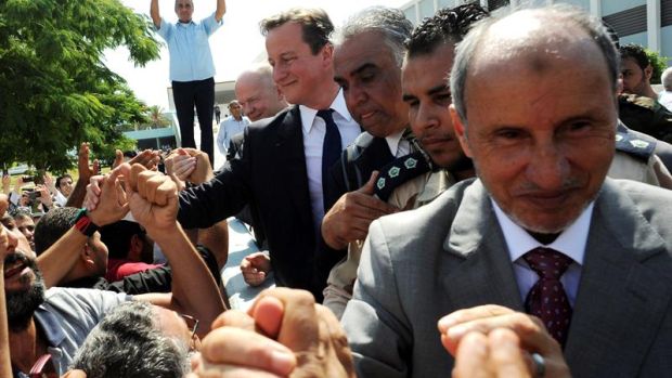 Líder do Conselho Nacional de Transição da Líbia, Mustafa Abdul Jalil cumprimenta líbios com Cameron