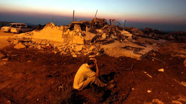Colono judeu ao lado de sua casa destruída pelas forças de segurança israelenses em Migron, Cisjordânia