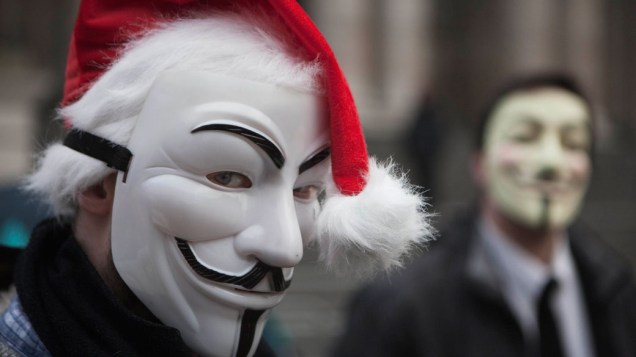 Manifestantes ingleses posam com máscara do revolucionário Guy Fawkes, em frente à catedral de São Paulo, em Londres - 24/12/2011
