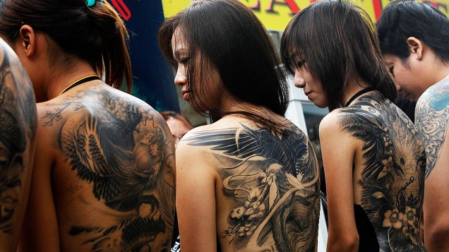 Concorrentes de concurso de tatuagens em Bancoc, na Tailândia exibem seus desenhos em área de shopping center. Concurso reúne cerca de 180 concorrentes