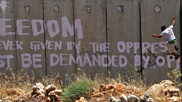 Palestino pula murro durante protesto na Vila de Karf Qaddum, perto de Nablus Palestino pula murro durante protesto na Vila de Karf Qaddum, perto de Nablus