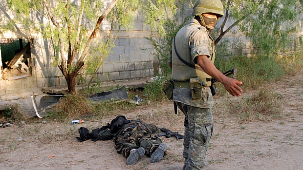 Militar mexicano diante do corpo de traficante mortos em confronto: país registrou mais de 15 mil mortes relacionadas ao narcotráfico em 2010.
