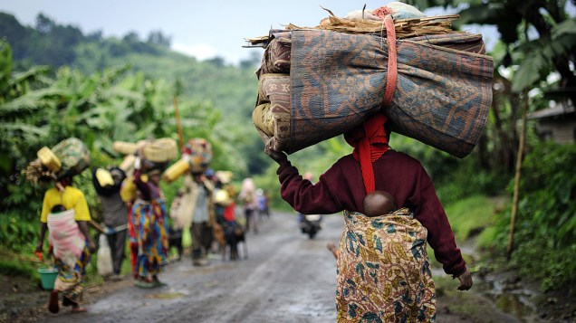 Congoleses deixam aldeia de Kabindi, na República Democrática do Congo, território de Rutshuru. Combates entre o exército congolês e os rebeldes forçou outra onda de pessoas a deixarem suas casas