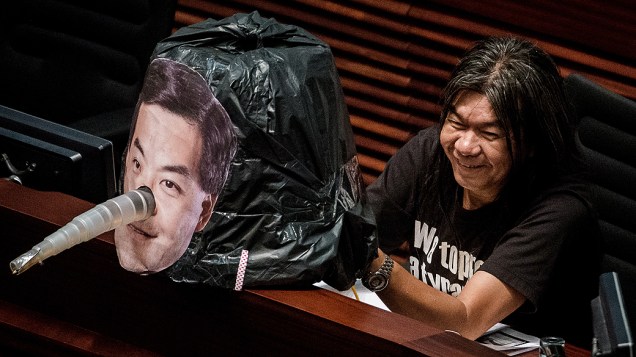 Membro do conselho legislativo Leung Kwok-Hung, mostra imagem do chefe do executivo de Hong Kong, Leung Chun-ying, com nariz de Pinóquio como forma de protesto