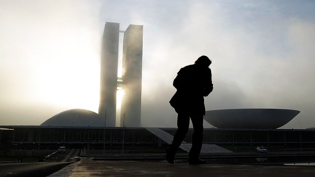 Homem caminha próximo ao Congresso Nacional em Brasília, onde será velado o corpo do arquiteto Niemeyer, nesta quinta-feira