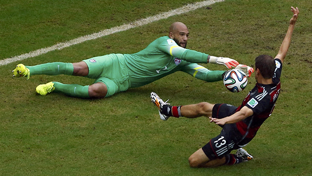 O alemão, Thomas Mueller, desafia goleiro Tim Howard, dos Estados Unido, durante partida em Recife